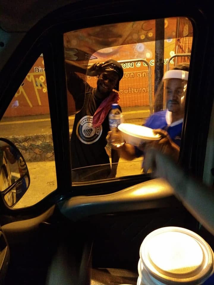 Voluntários do Sorriso em Ação entregando agasalhos e alimentos a moradores de rua em Parelheiros.